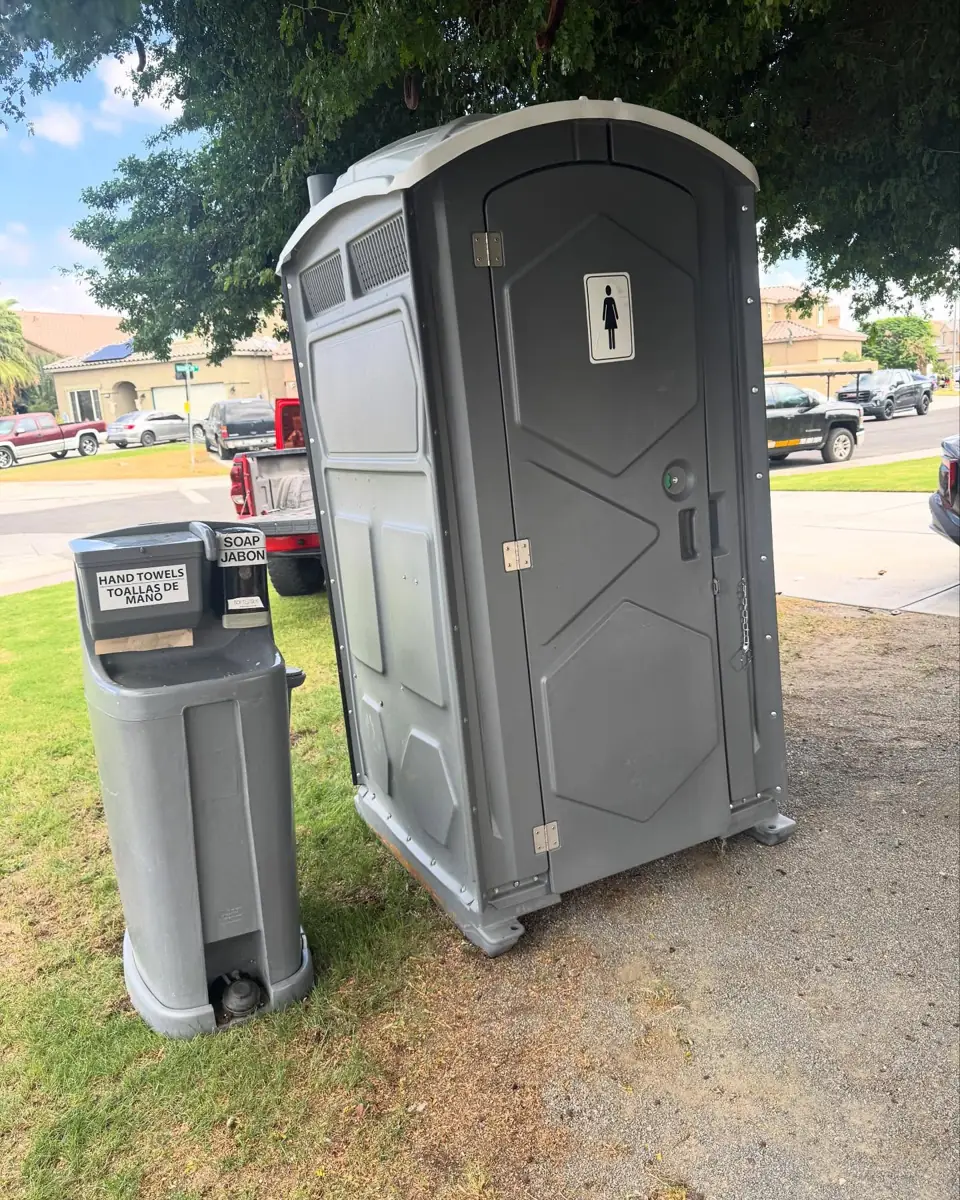 Portable toilet and hand wash station on a residential lawn